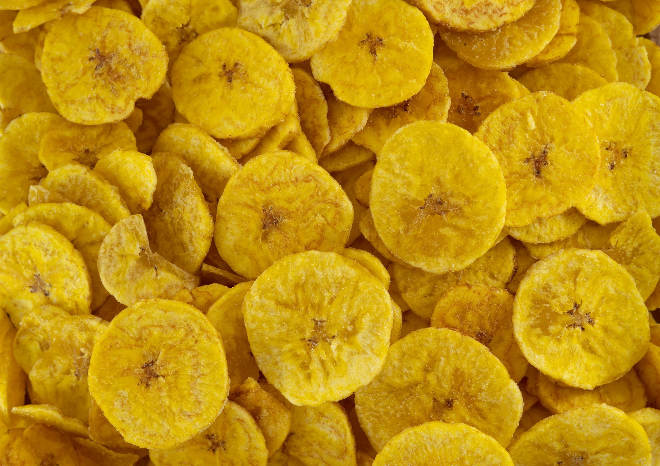 Pile of dehydrated fried banana chips with salt, top view. Chifles, tostones o patacones. Top view of typical traditional dish of Latin American gastronomy called Chifles or fried tostones. Platano.